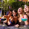 3 kobiety delektujące się drinkami na wewnętrznym basenie w otoczeniu tropikalnych roślin